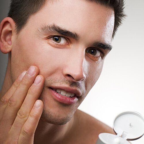 Woman applying primer to smooth forehead lines
