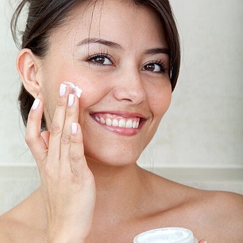 Woman organizing a layered winter skin care routine.