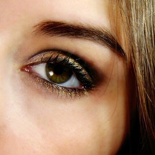 Woman applying neutral eye shadow for subtle contour.
