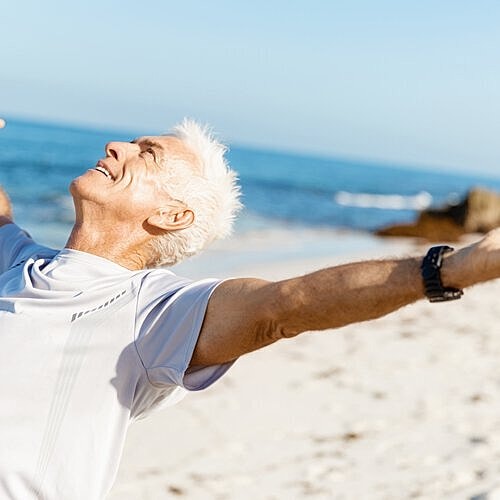 Man relaxing at the beach after cosmetic surgery
