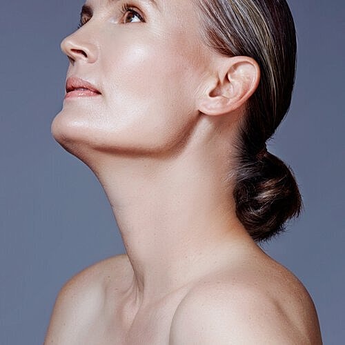 Woman touching smooth skin after laser resurfacing treatment.