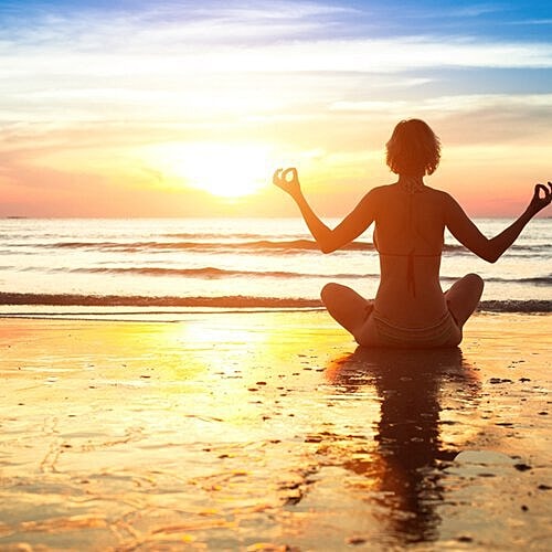 Woman relaxing outdoors with glowing skin.
