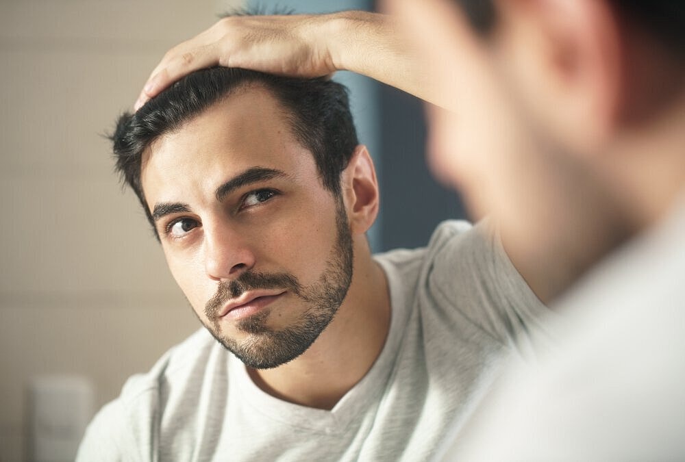 Smiling man touching his restored hair