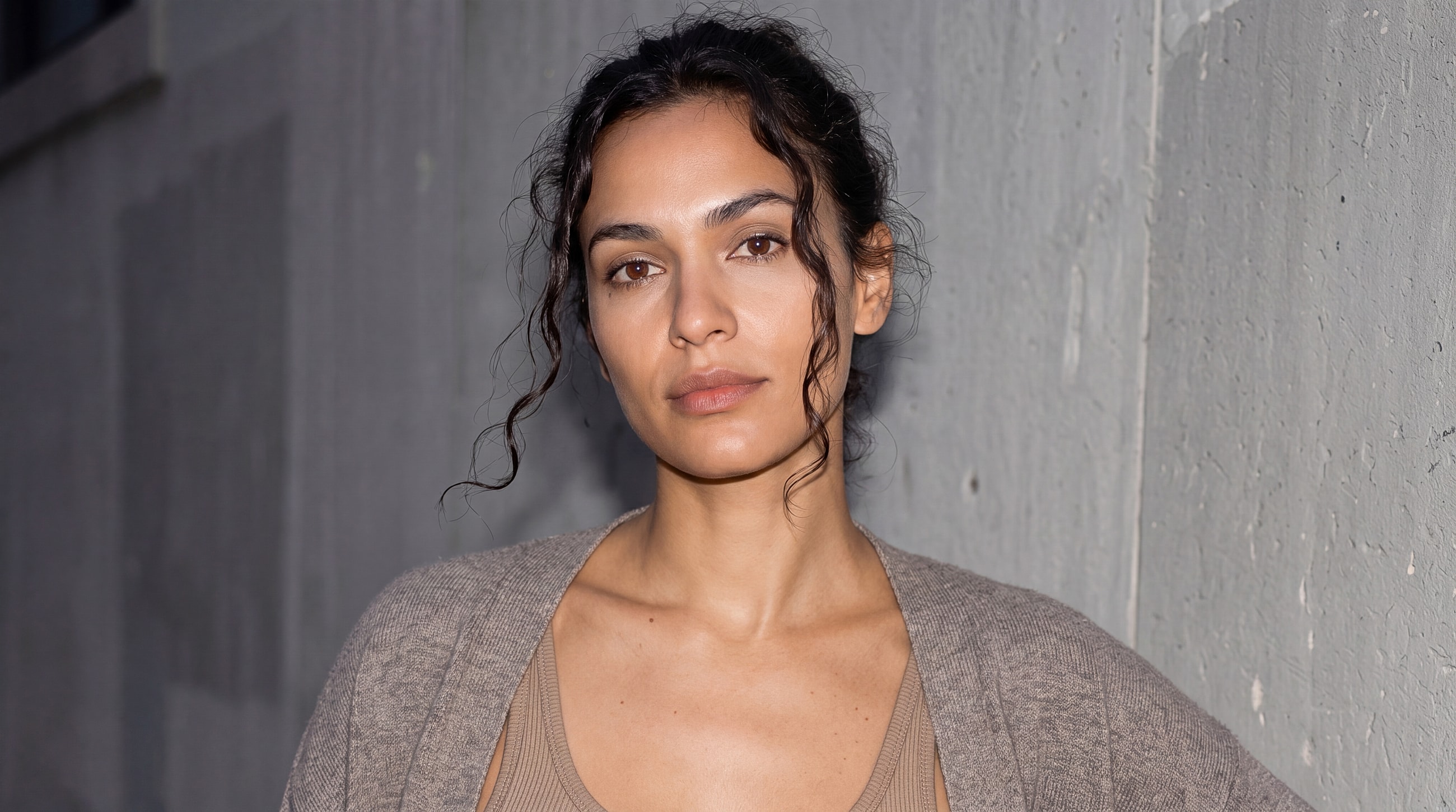 Woman with wavy hair against a grey background.