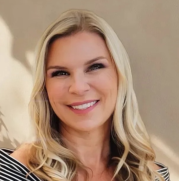Smiling woman with blonde, wavy hair.