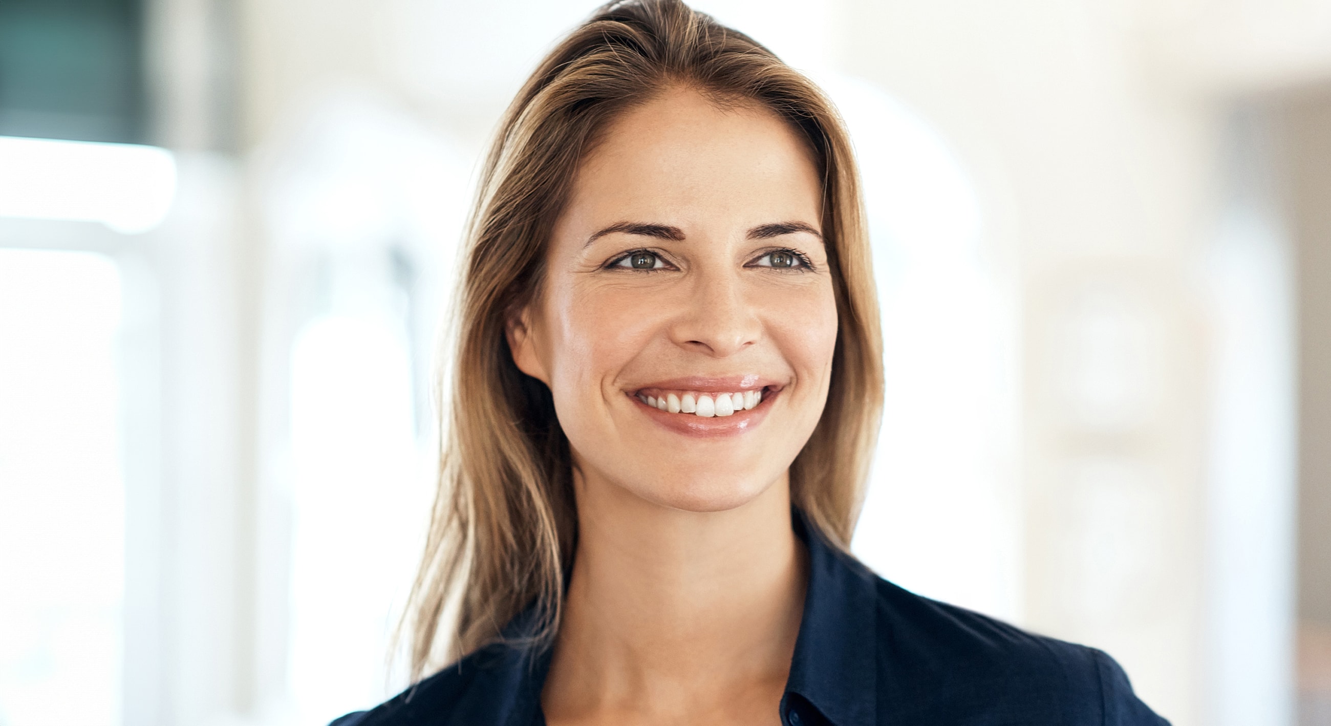 Smiling woman in casual clothing, natural light.