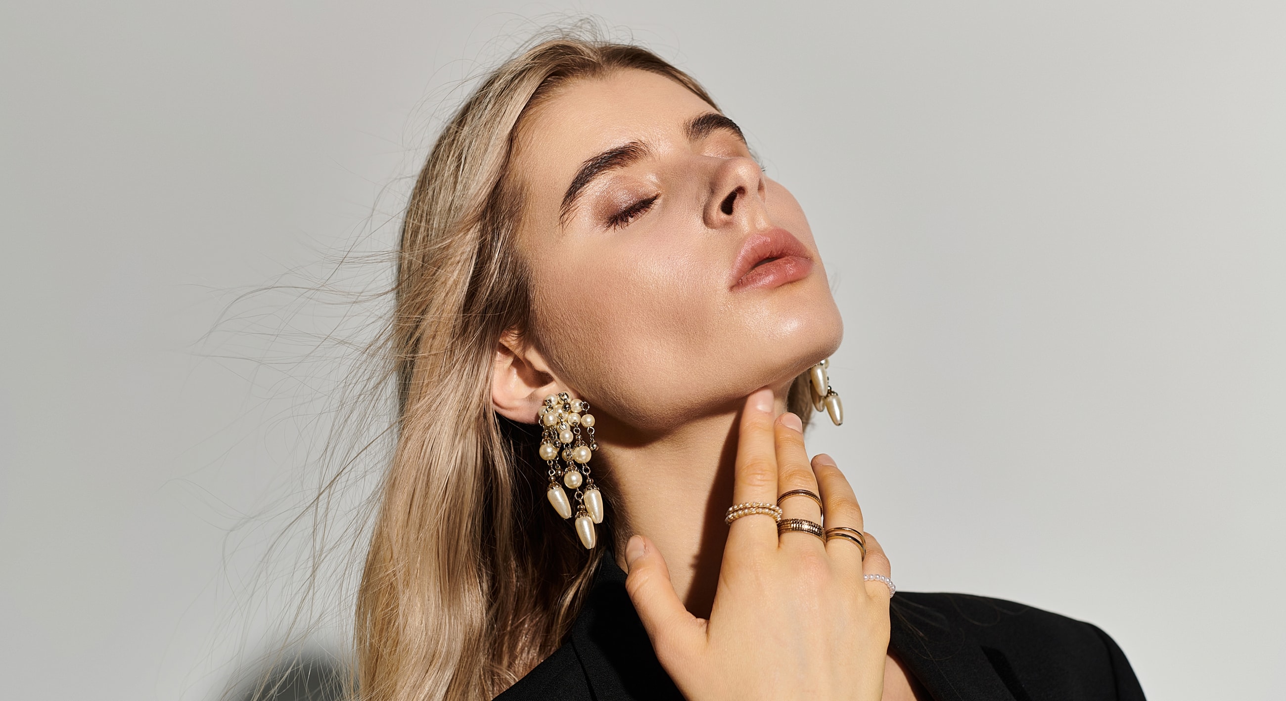 Woman wearing elegant jewelry, posing gracefully.