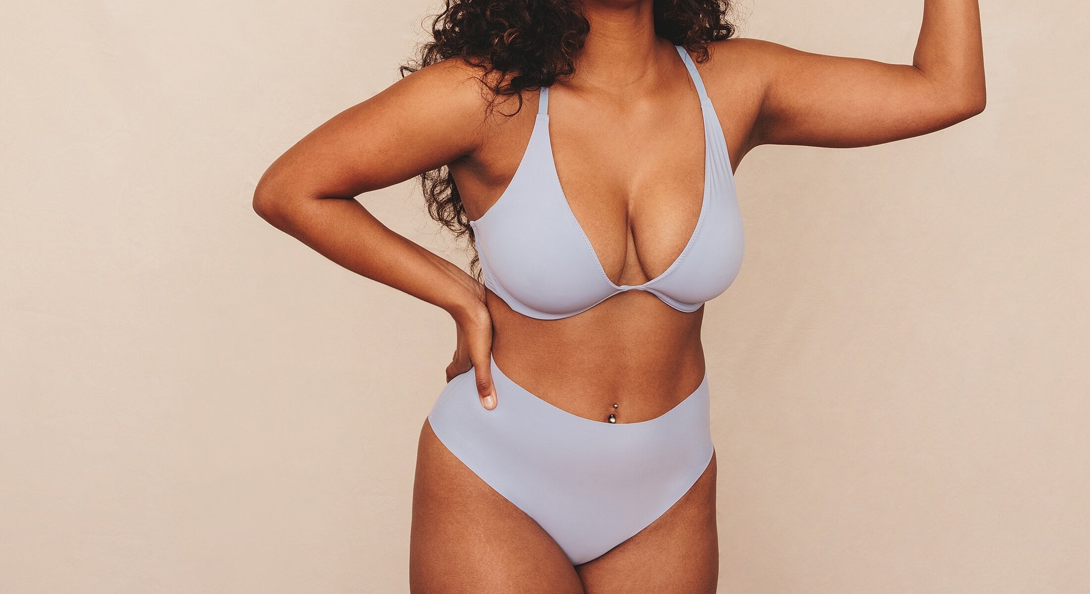Model wearing blue lingerie, posing confidently.