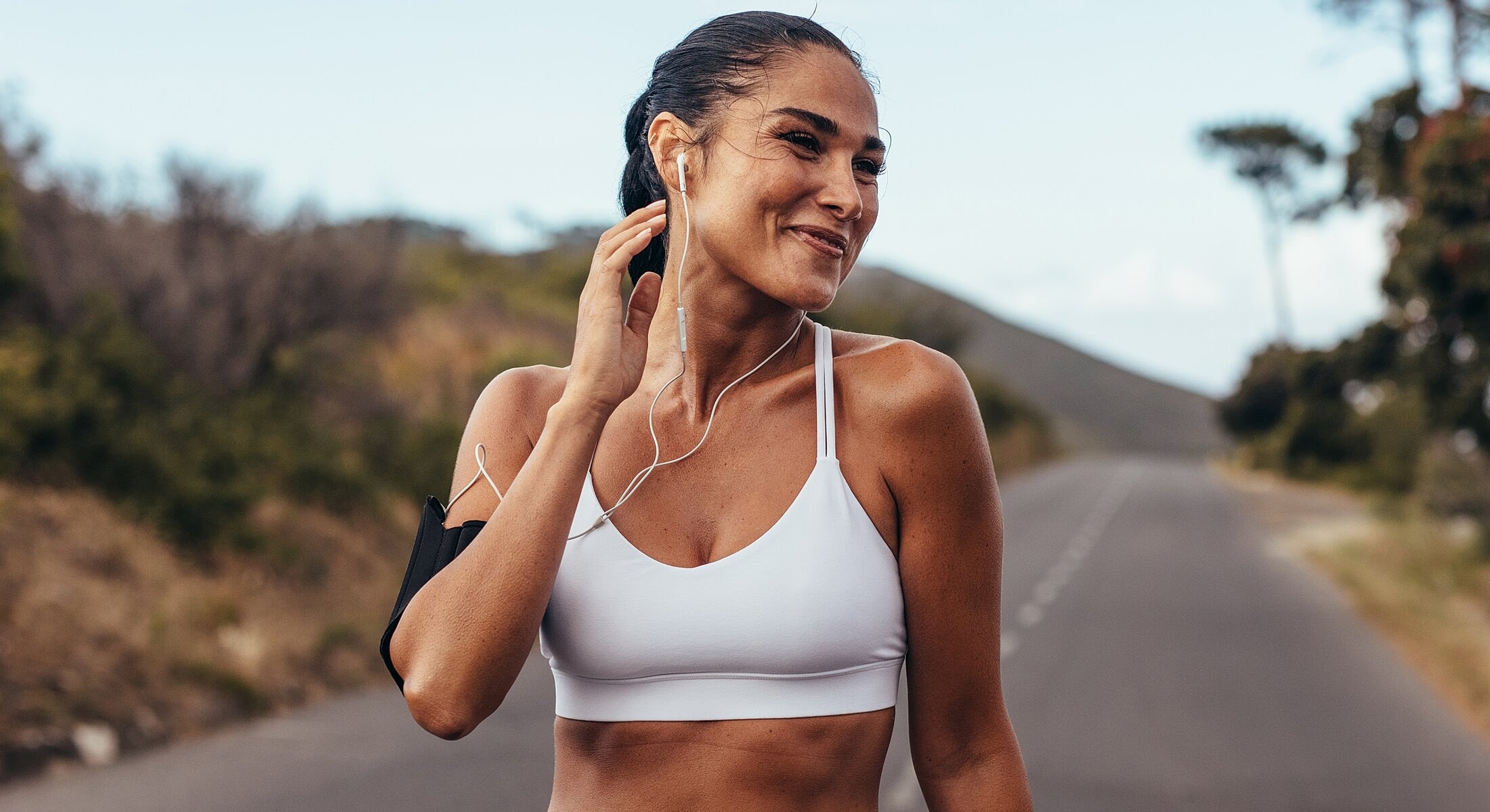 Woman enjoying music while running outdoors.