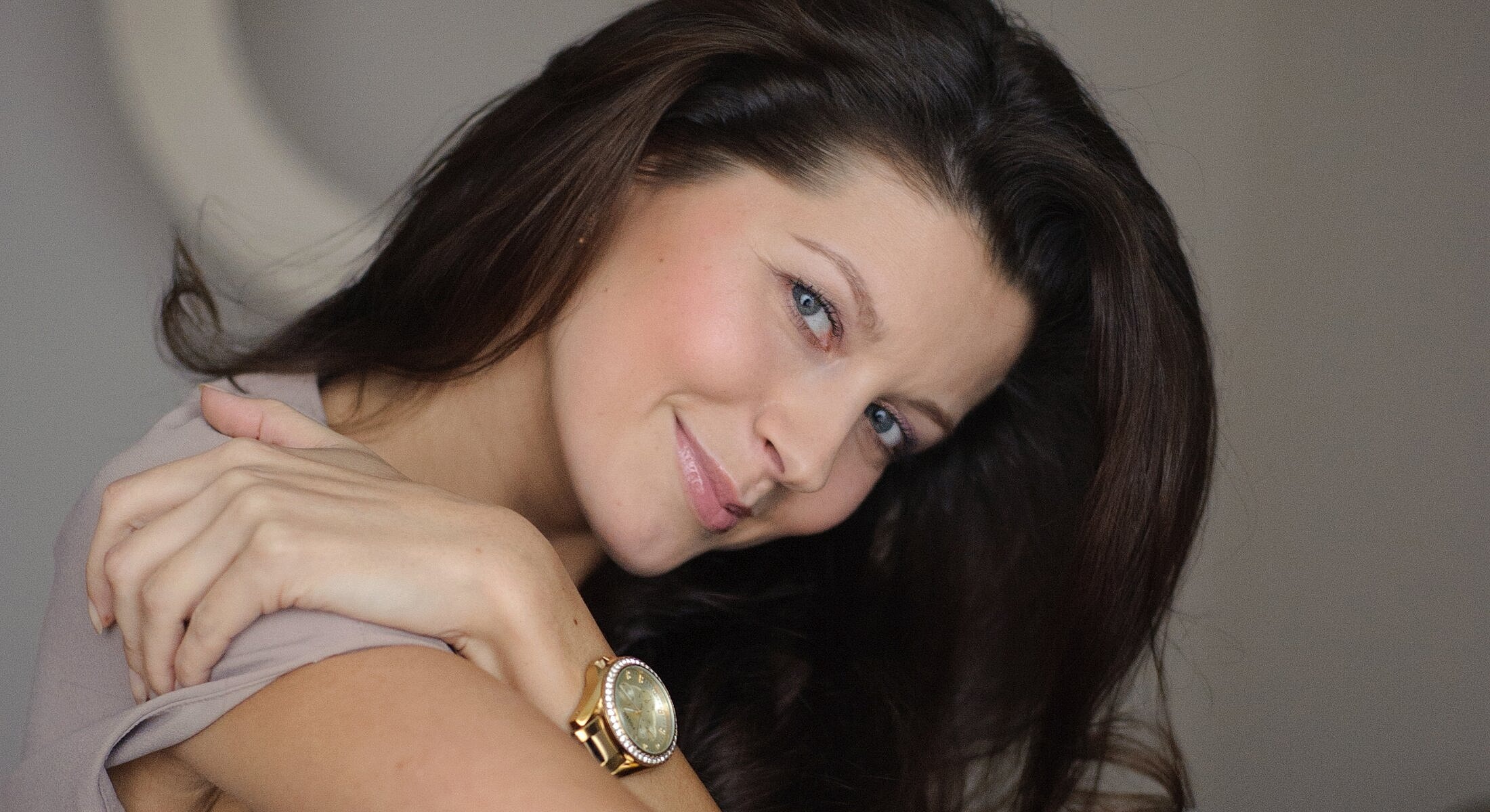 Woman with long hair and stylish watch.