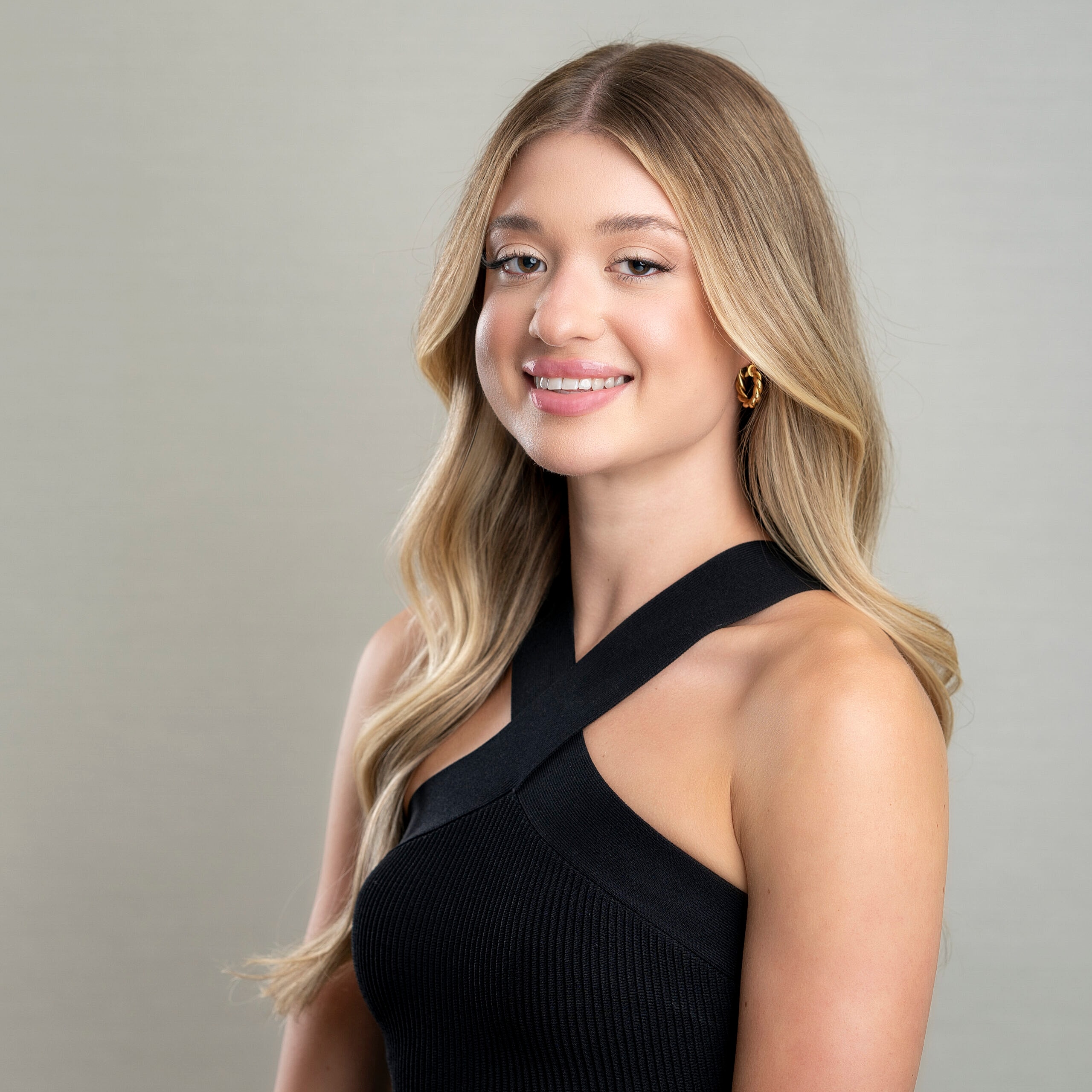 Smiling woman with long hair in black outfit.