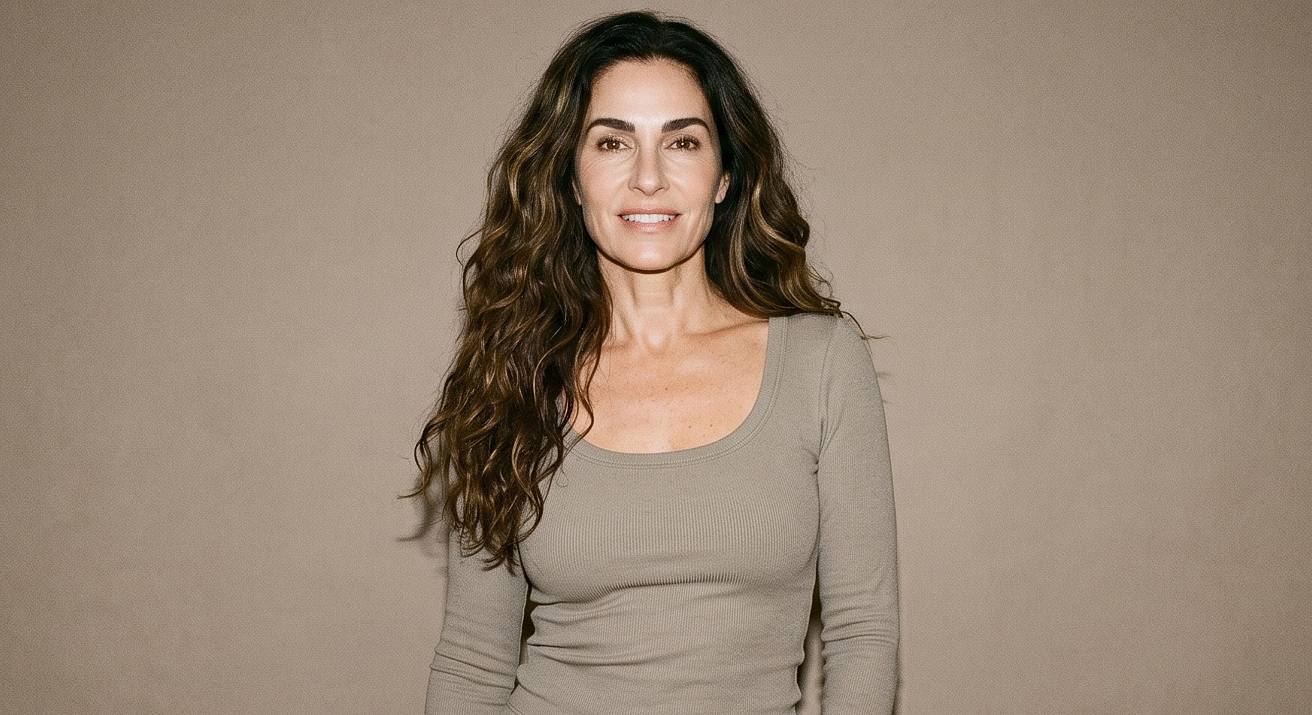 Smiling woman with long, wavy hair.