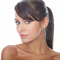 Woman touching cheek with facial redness