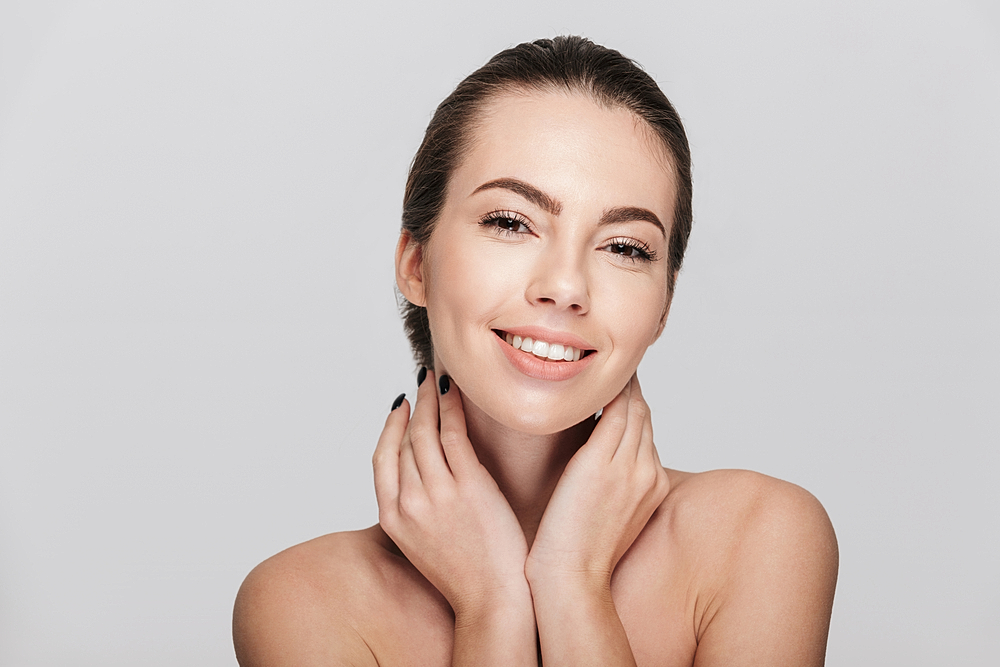woman applying mineral sunscreen to face