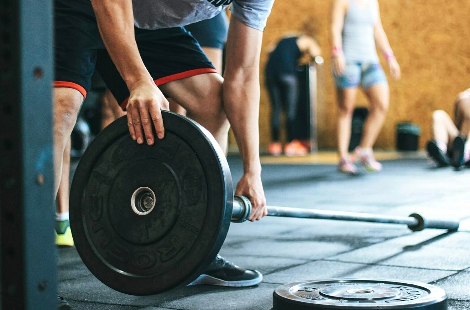 Man Assembling Barbell in Gym