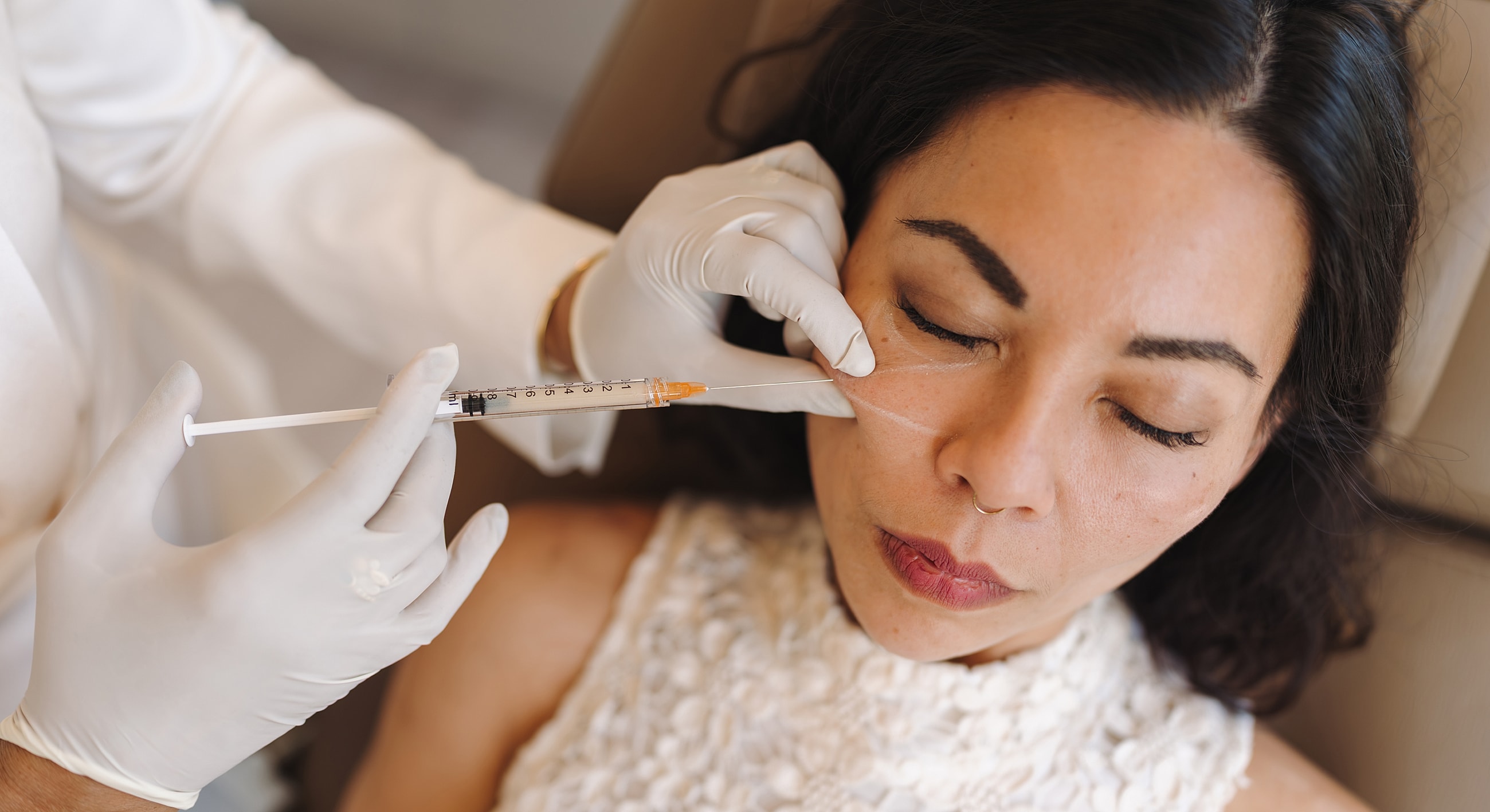 Cosmetic treatment with injection near the eye.