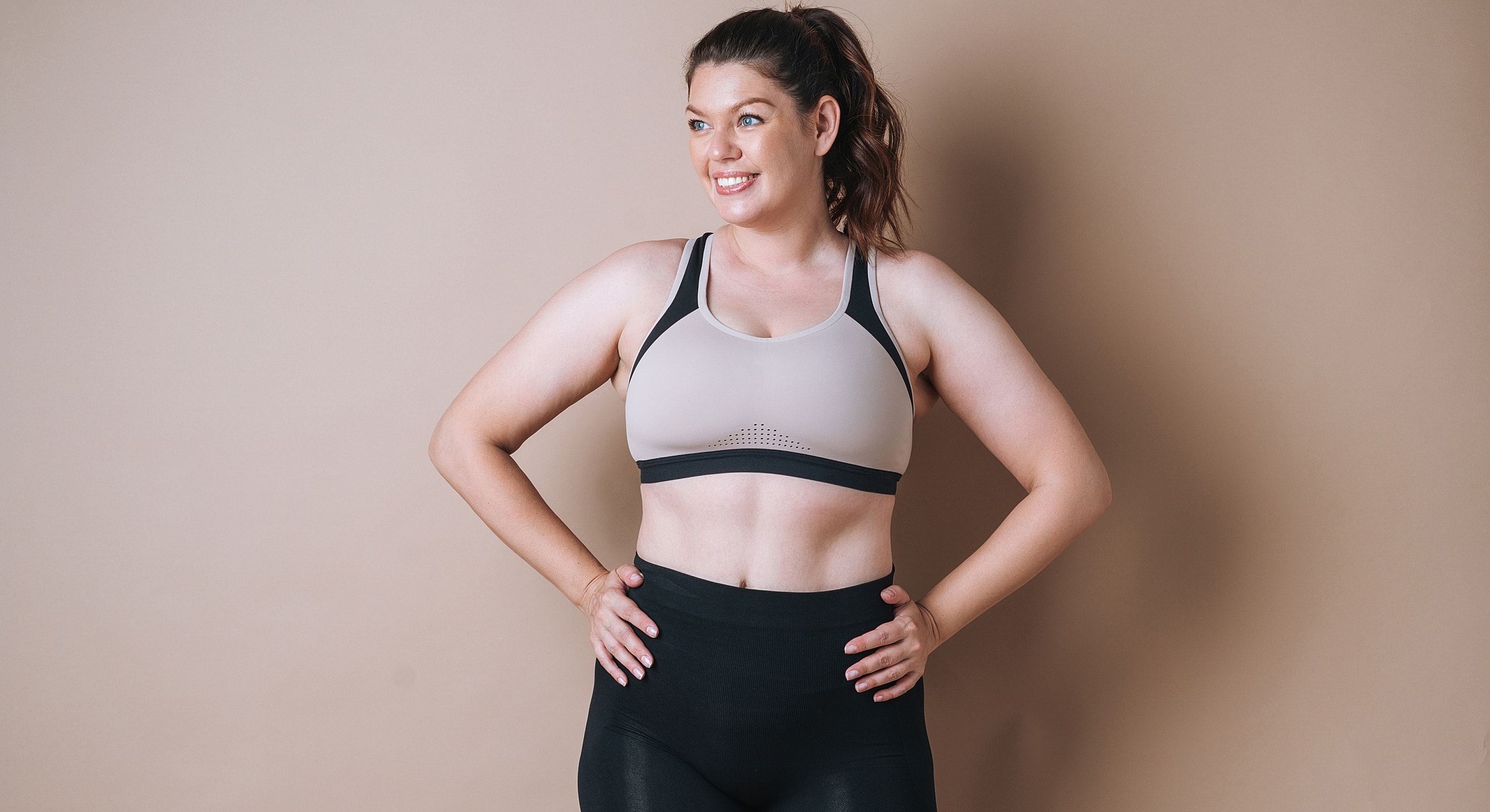 Smiling woman in athletic wear posing confidently.