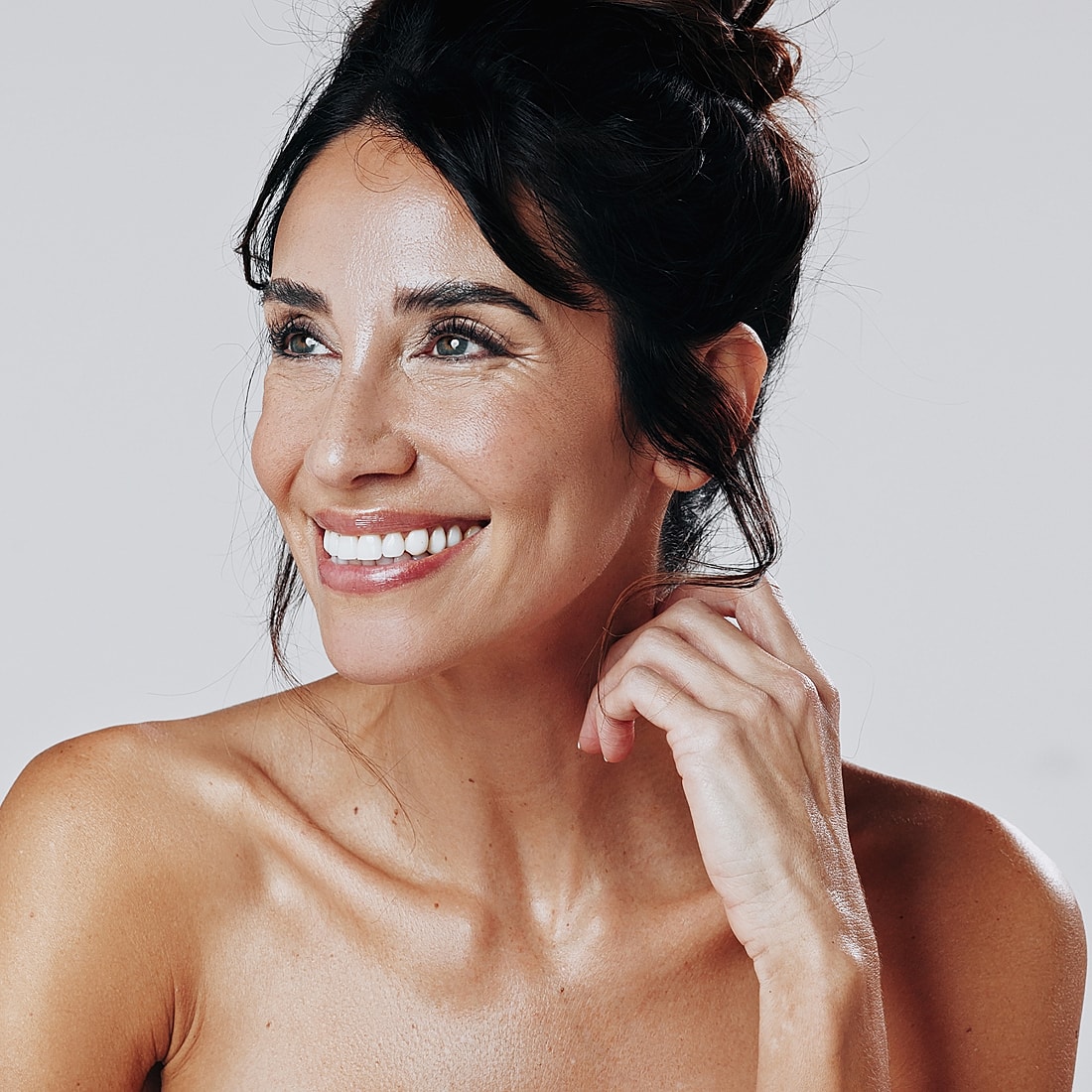 Smiling woman with clear skin and tousled hair.