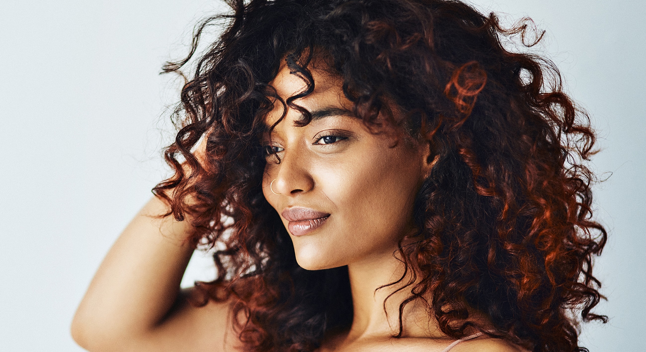 Woman with curly hair and confident expression.