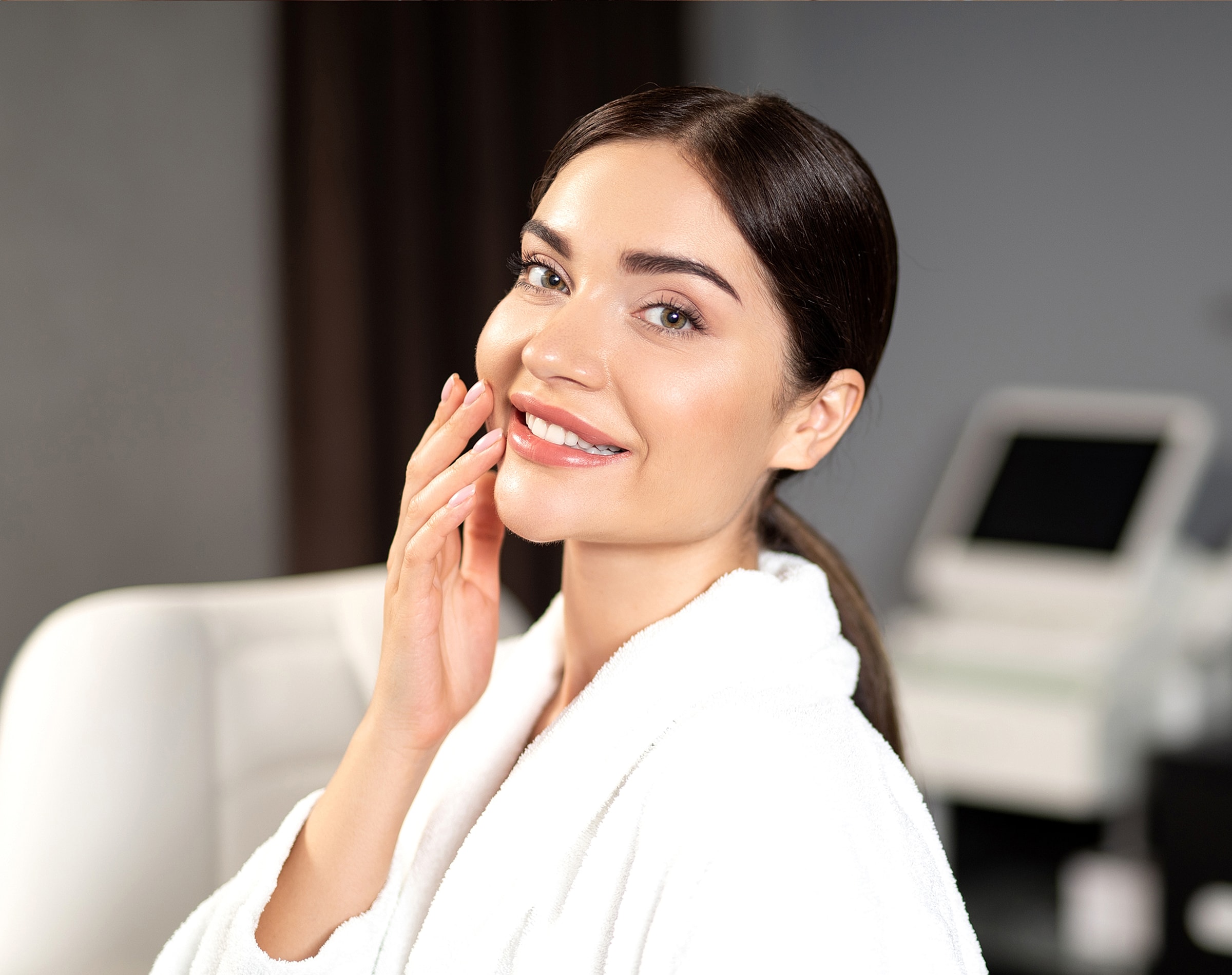 Smiling woman in a spa robe indoors.