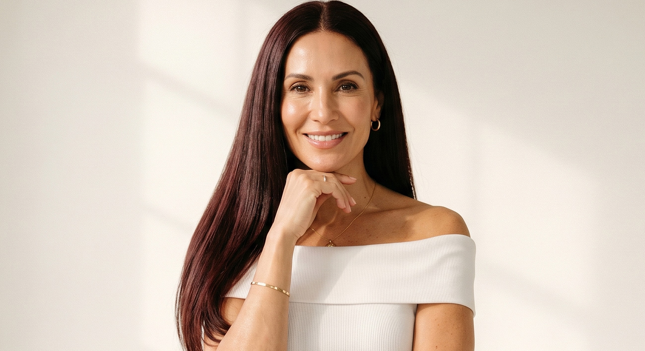 Portrait of a smiling woman in white top.