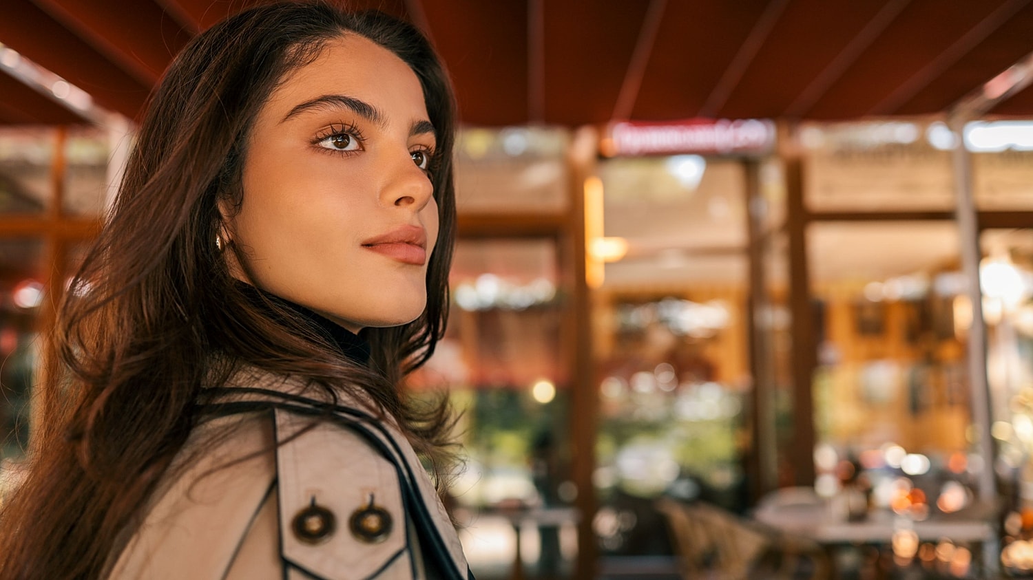 A woman with a defined jawline and lifted cheekbones looking thoughtfully into the distance following non-invasive facial treatment.