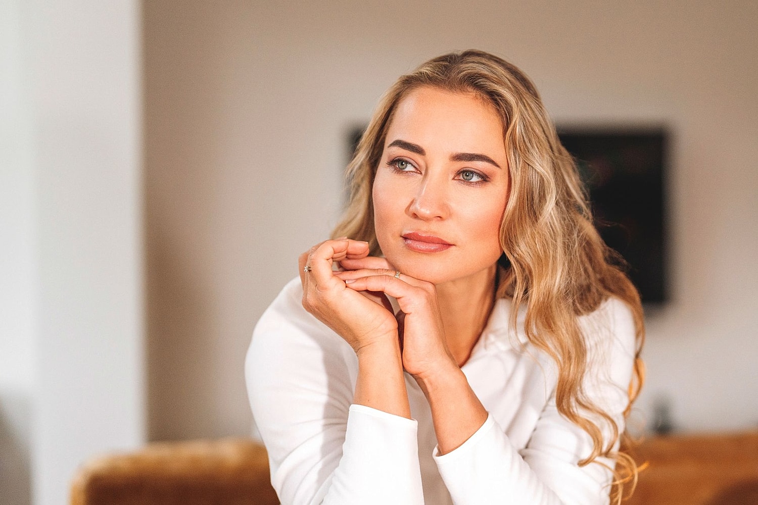 A woman with a defined jawline and athletic physique looking thoughtfully to the side, representing the results of Kybella treatments.