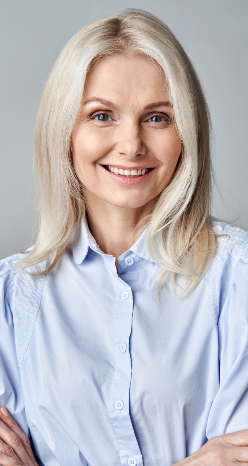 Smiling med spa patient model with long, light blonde hair.