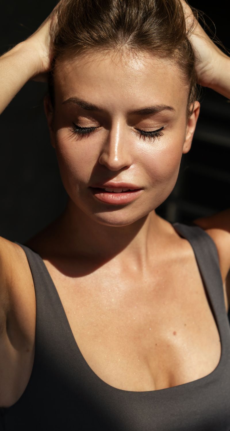 med spa patient model with closed eyes in soft lighting.
