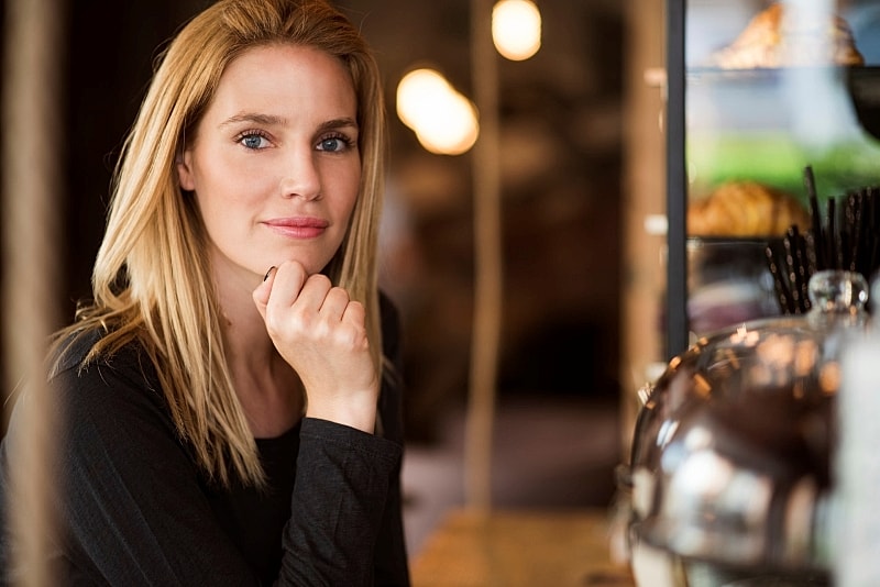 profile of a woman smiling sitting in a coffee shop