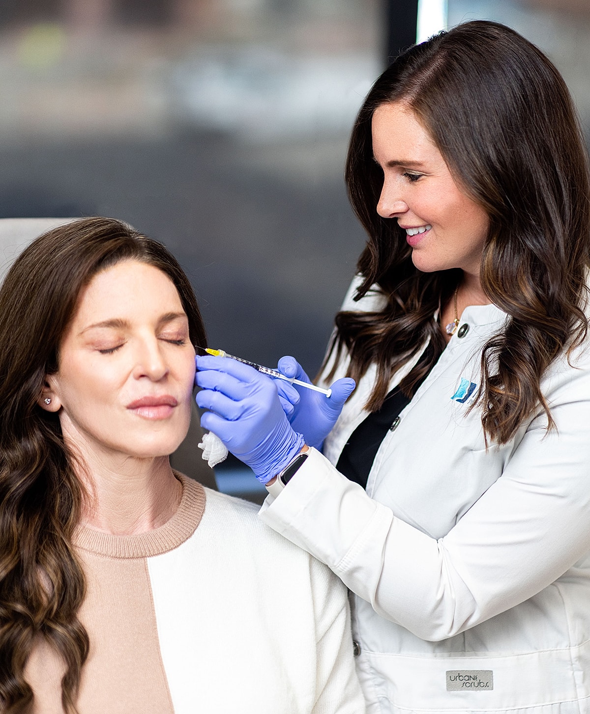 Smiling medical professional holding a syringe.
