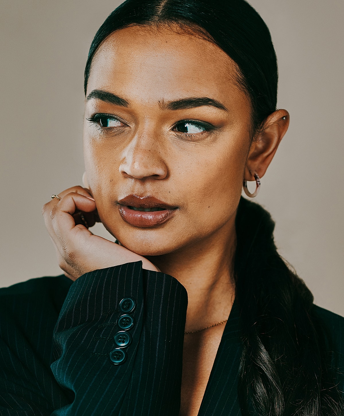 Woman in a suit with thoughtful expression.