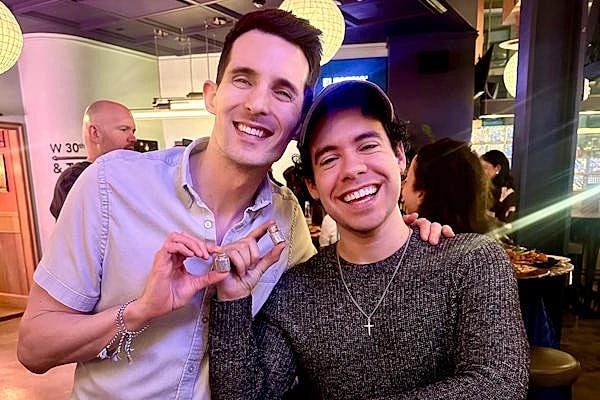 Two friends smiling at a social gathering.