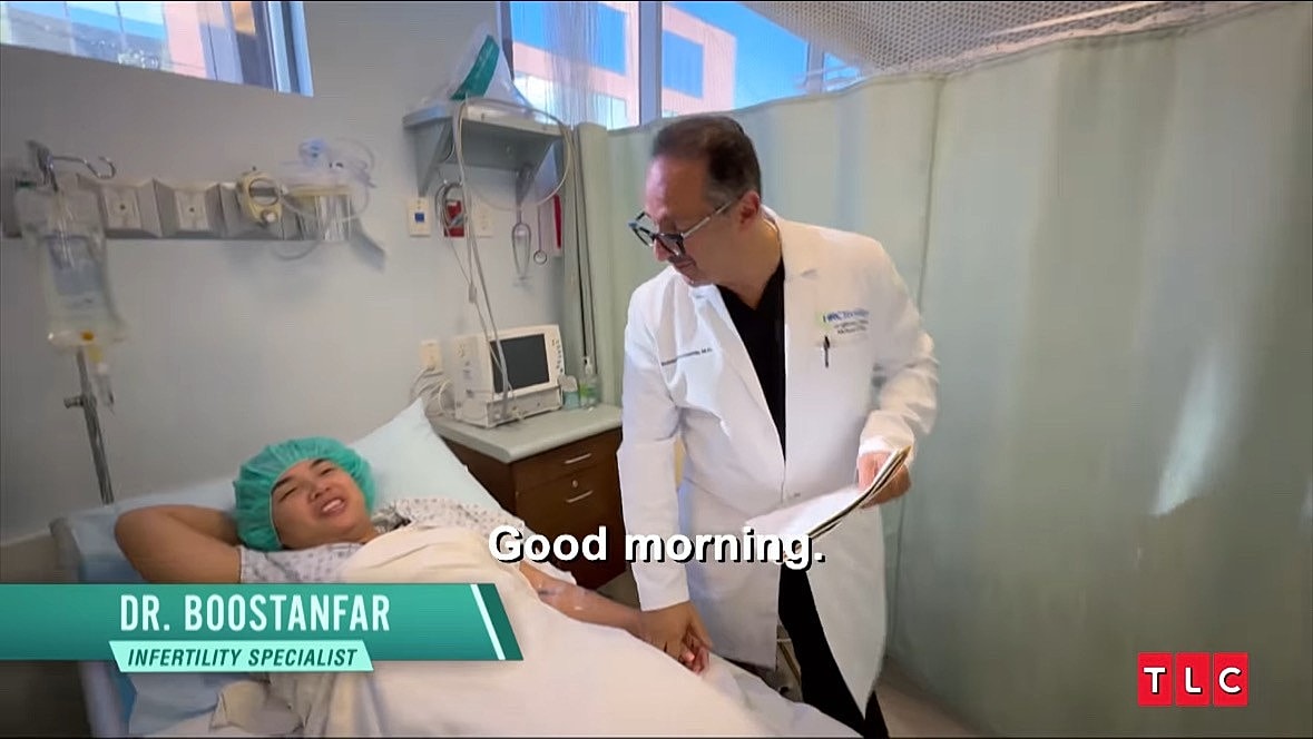 Doctor consulting with patient in a hospital room.