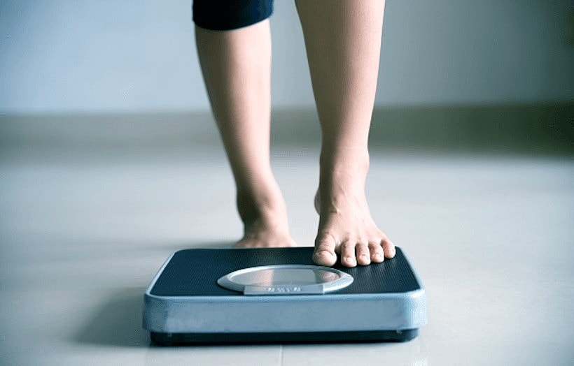 Person standing on a bathroom scale.