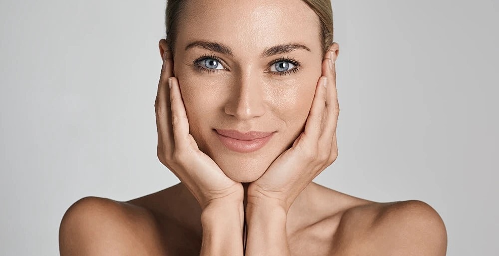Woman with radiant and clear skin after BBL therapy.