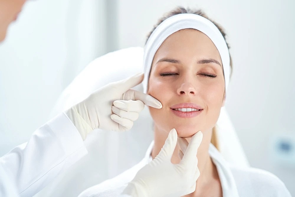 A doctor evaluates a woman’s face during a Botox consultation at a med spa.
