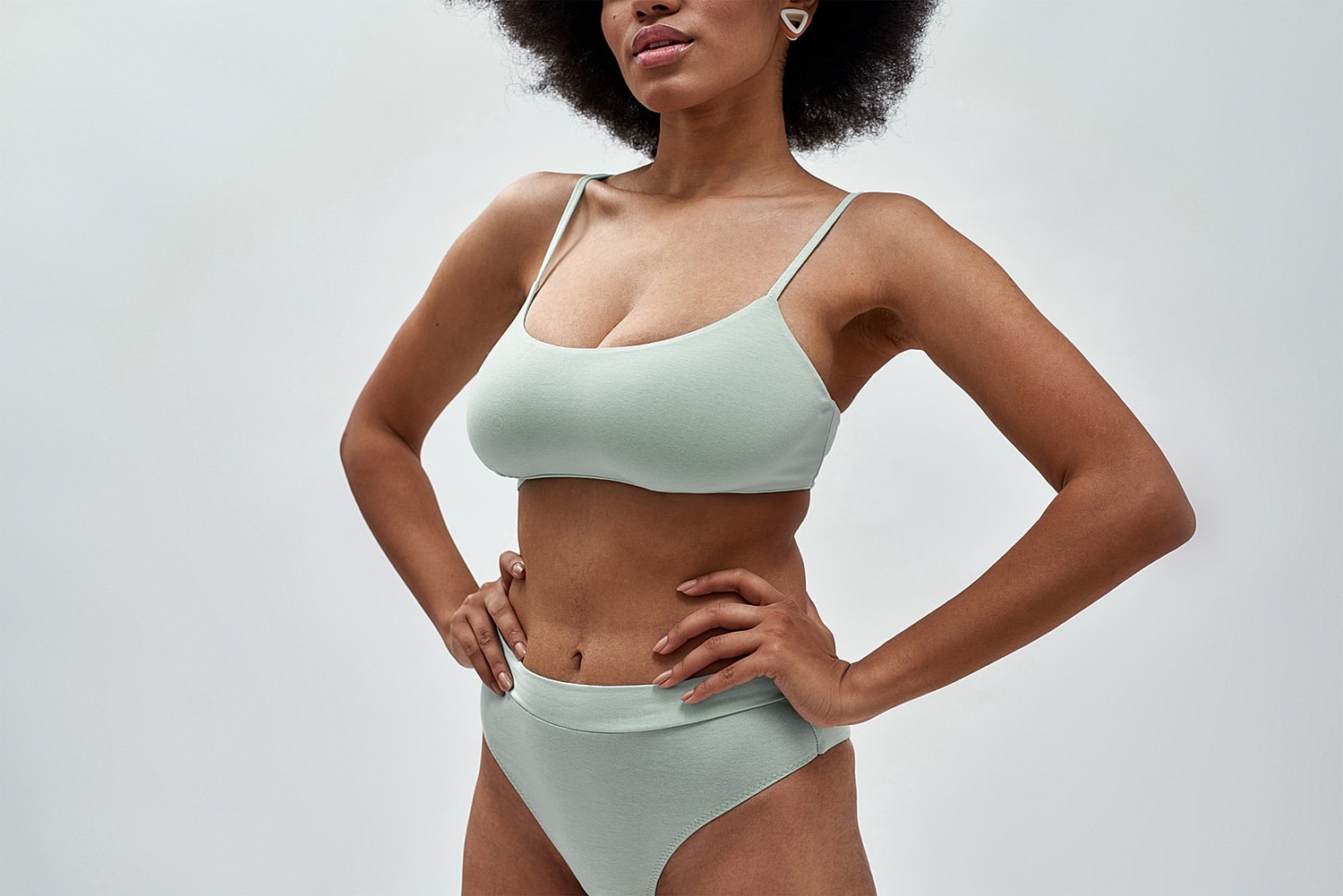 Model in mint green lingerie posing confidently.