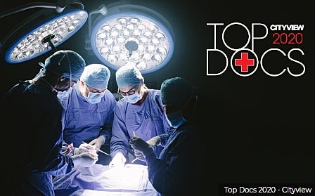 Surgeons performing surgery under bright lights.