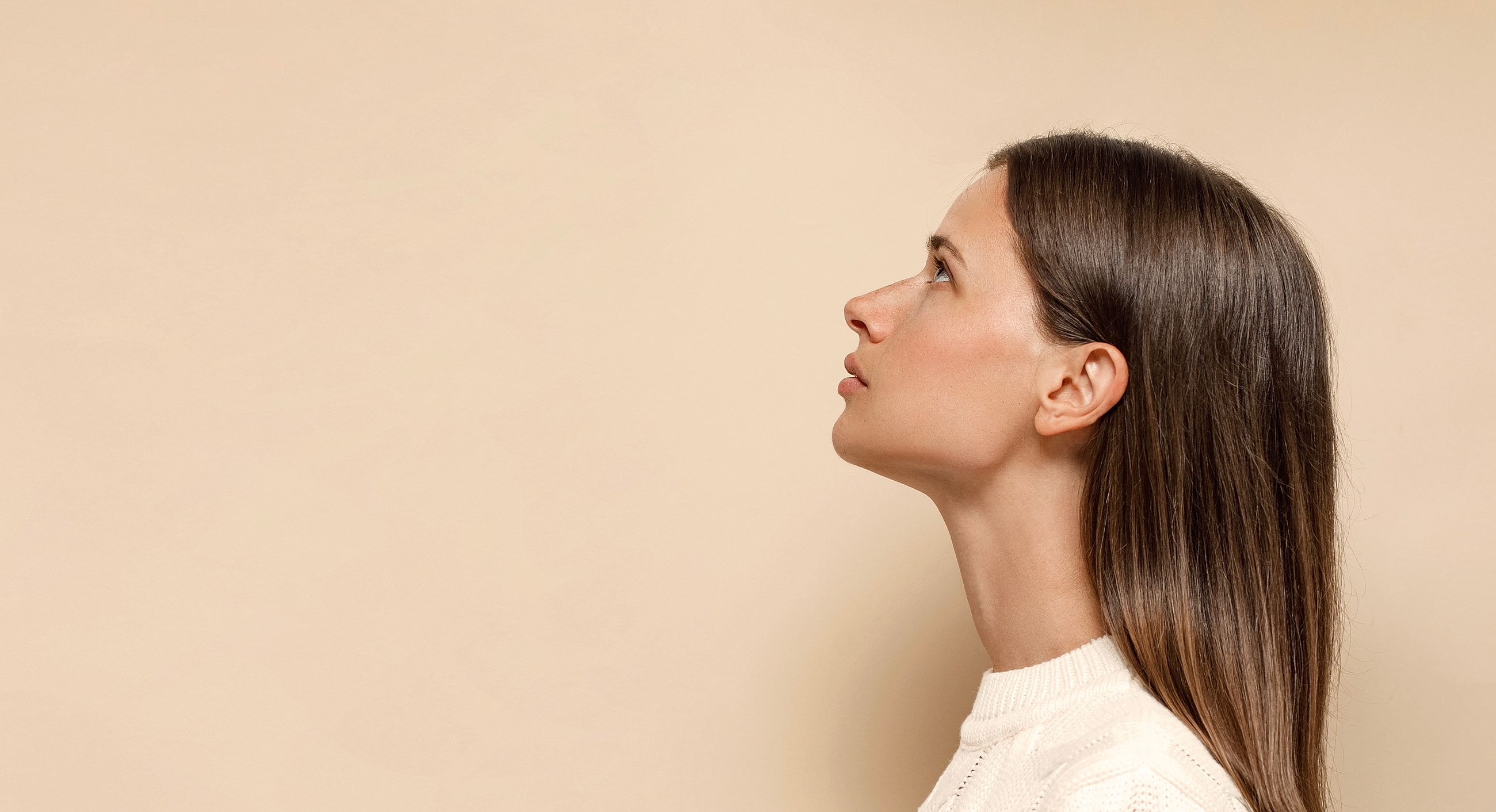 Profile view of woman against neutral background.