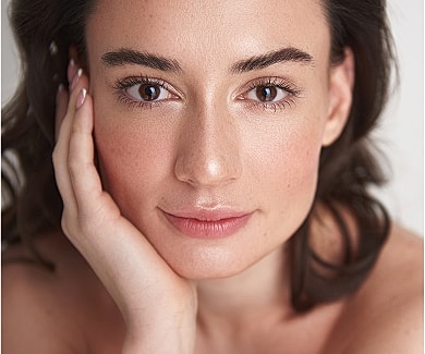 Skincare products arranged near a laptop.