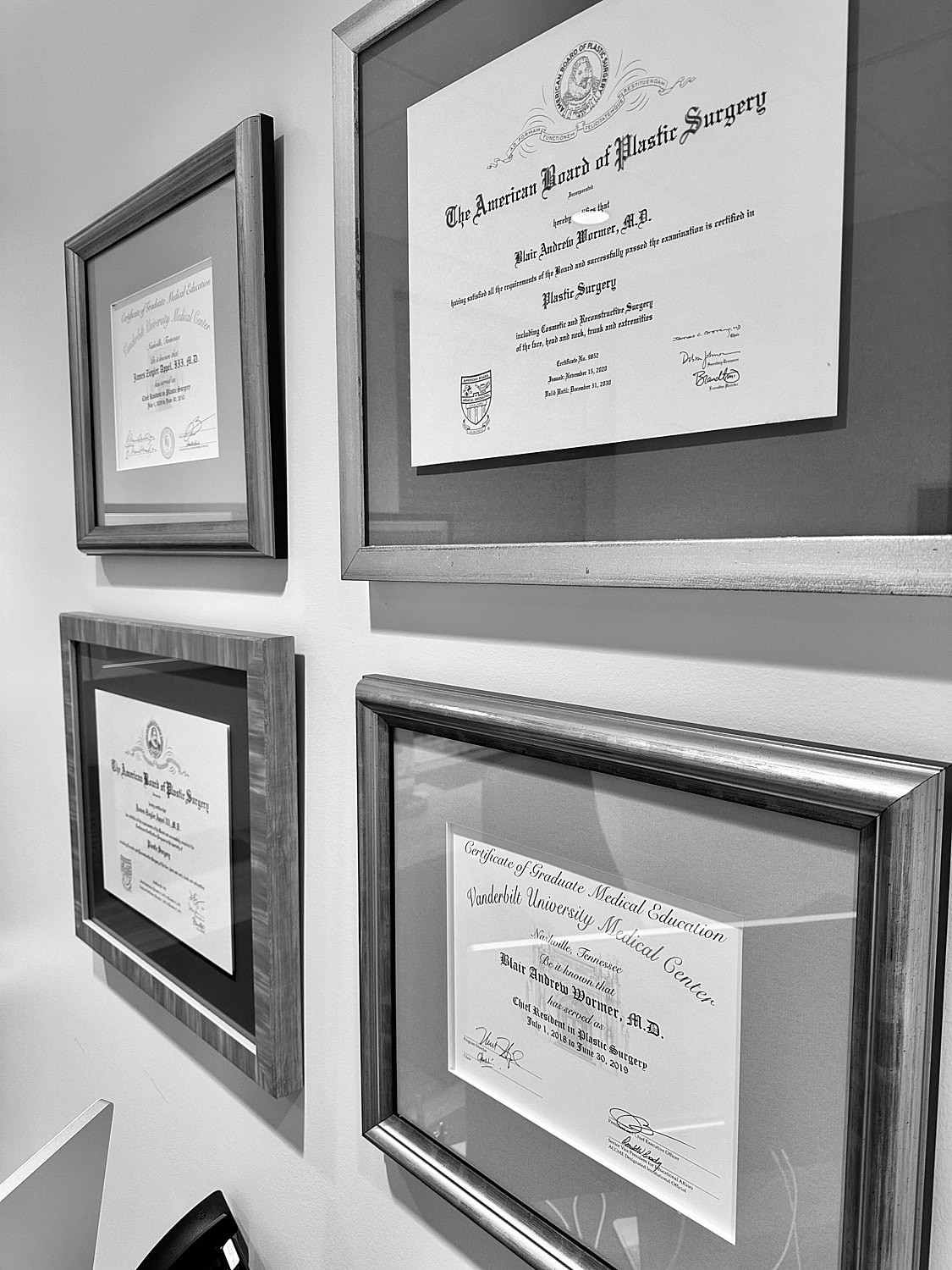 Framed medical and board certification diplomas.