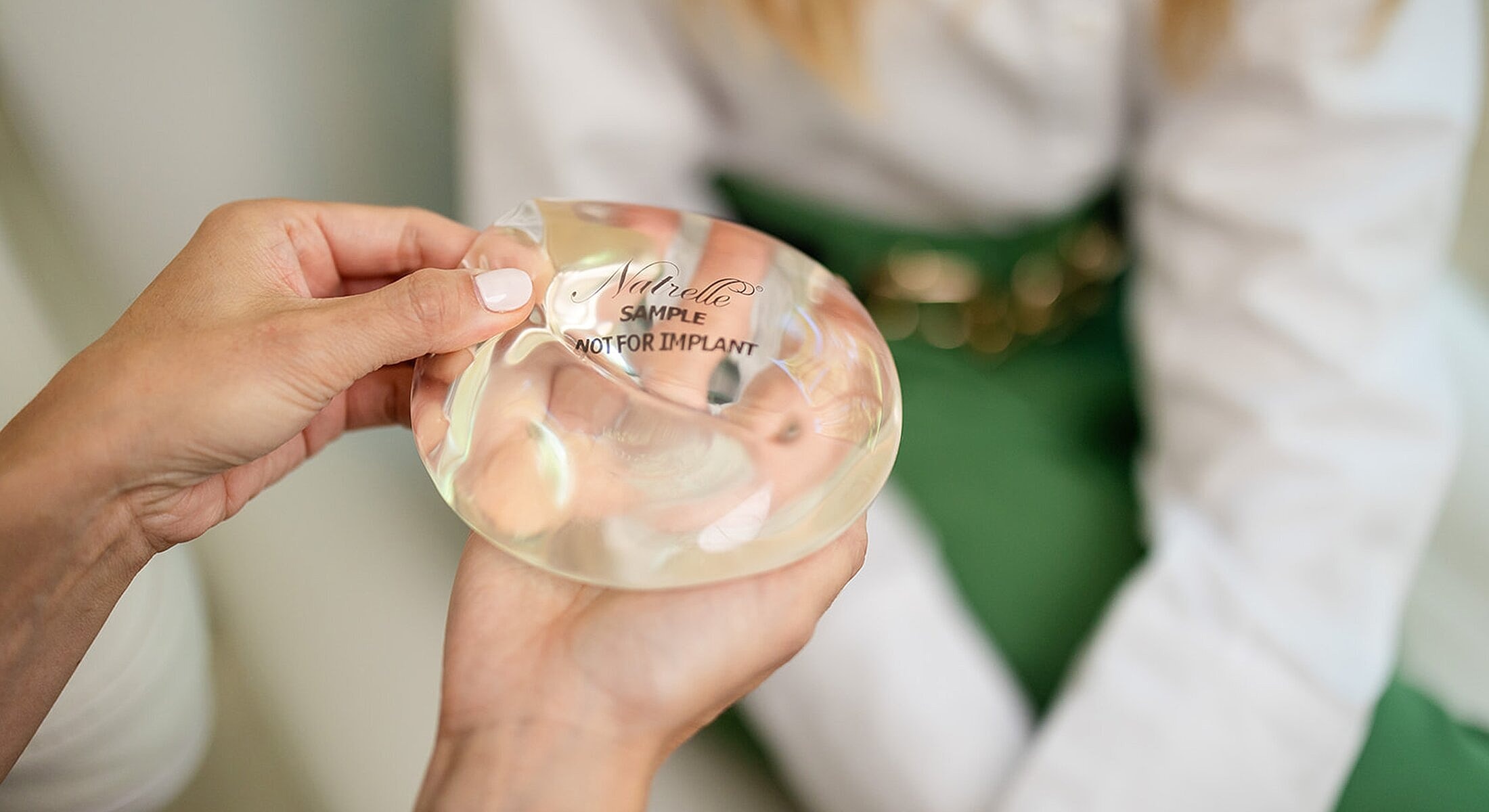 Sample silicone breast implant being held.