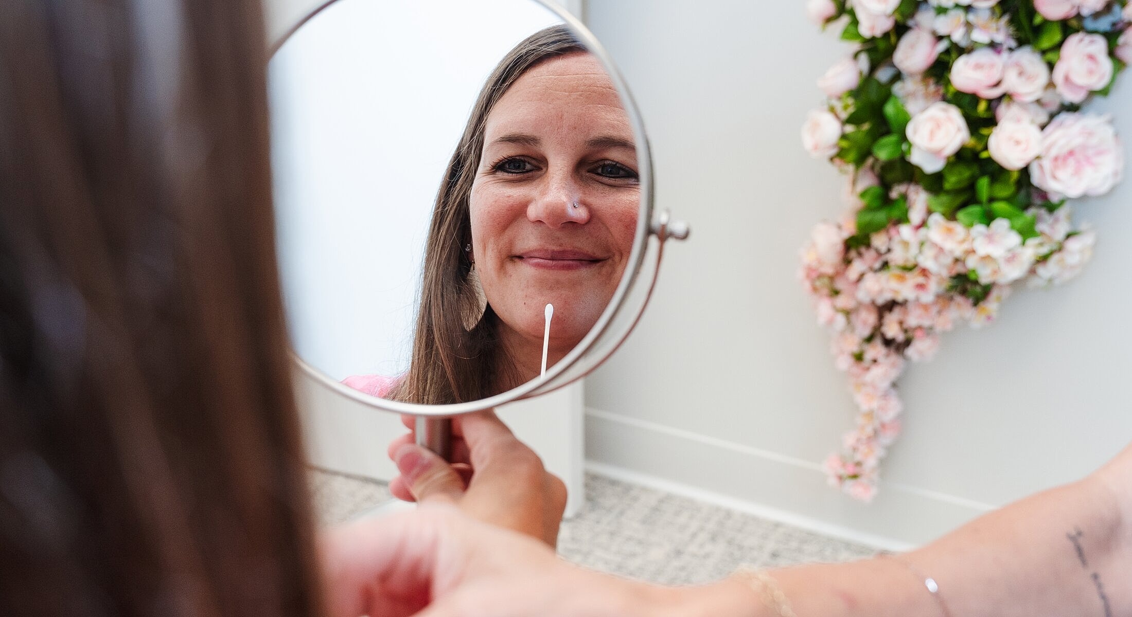 Woman smiling while looking in mirror.