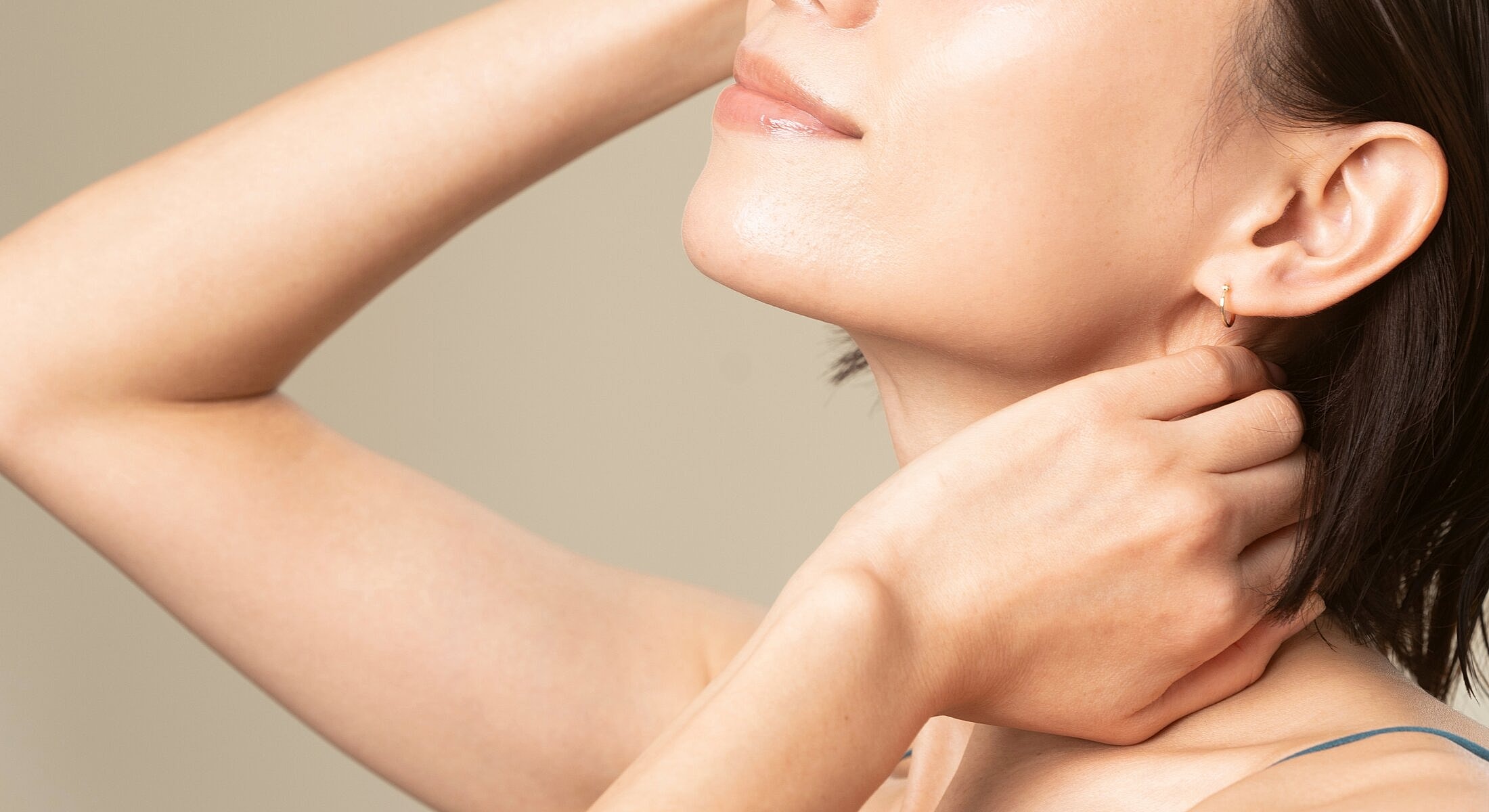 Close-up of woman touching her neck.