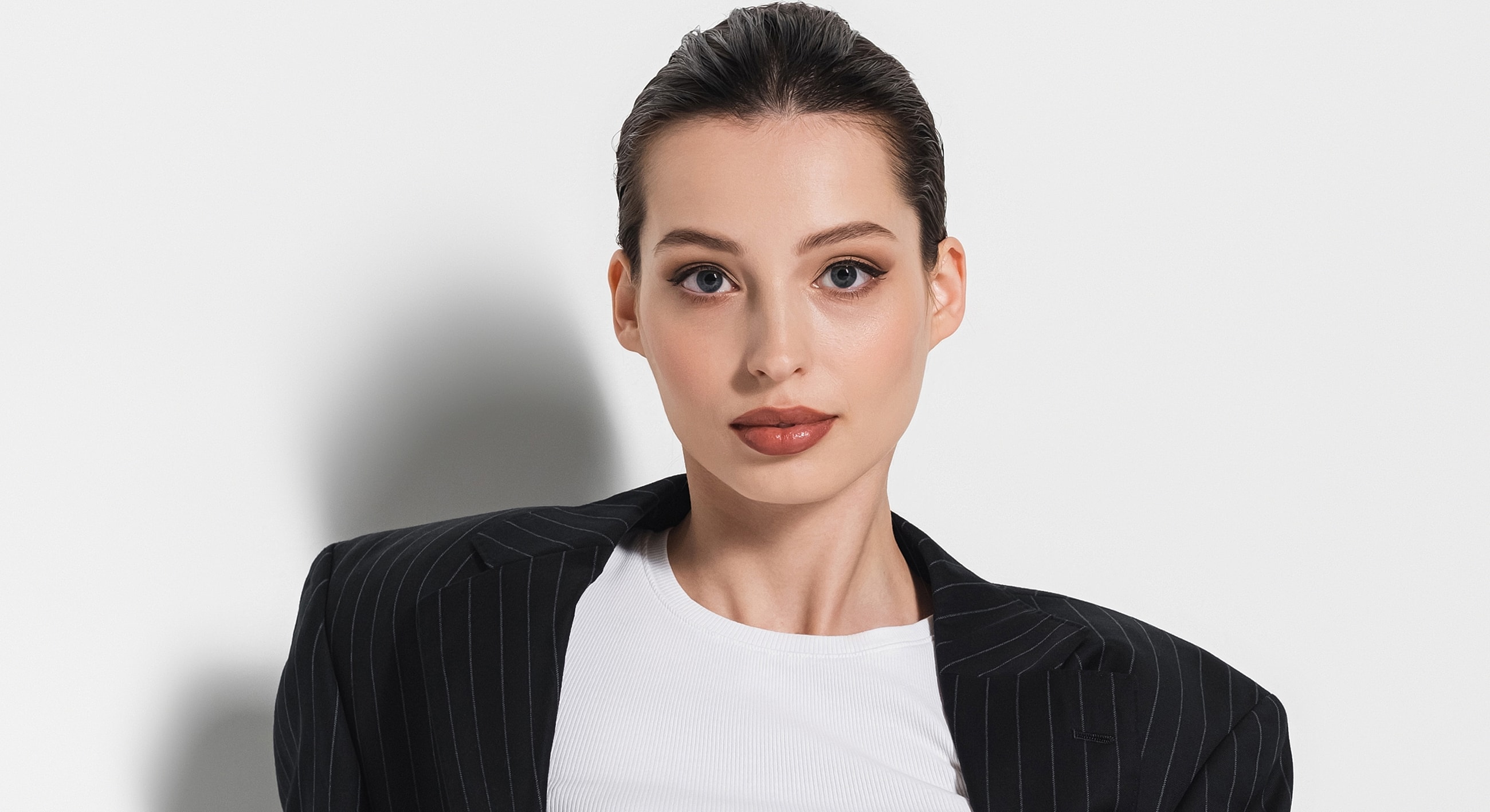 Woman in stylish blazer against white background.