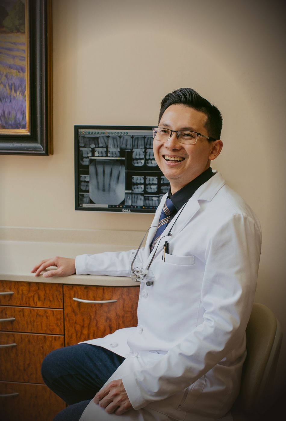 Newport beach dentist - Dr. Chau sitting at desk