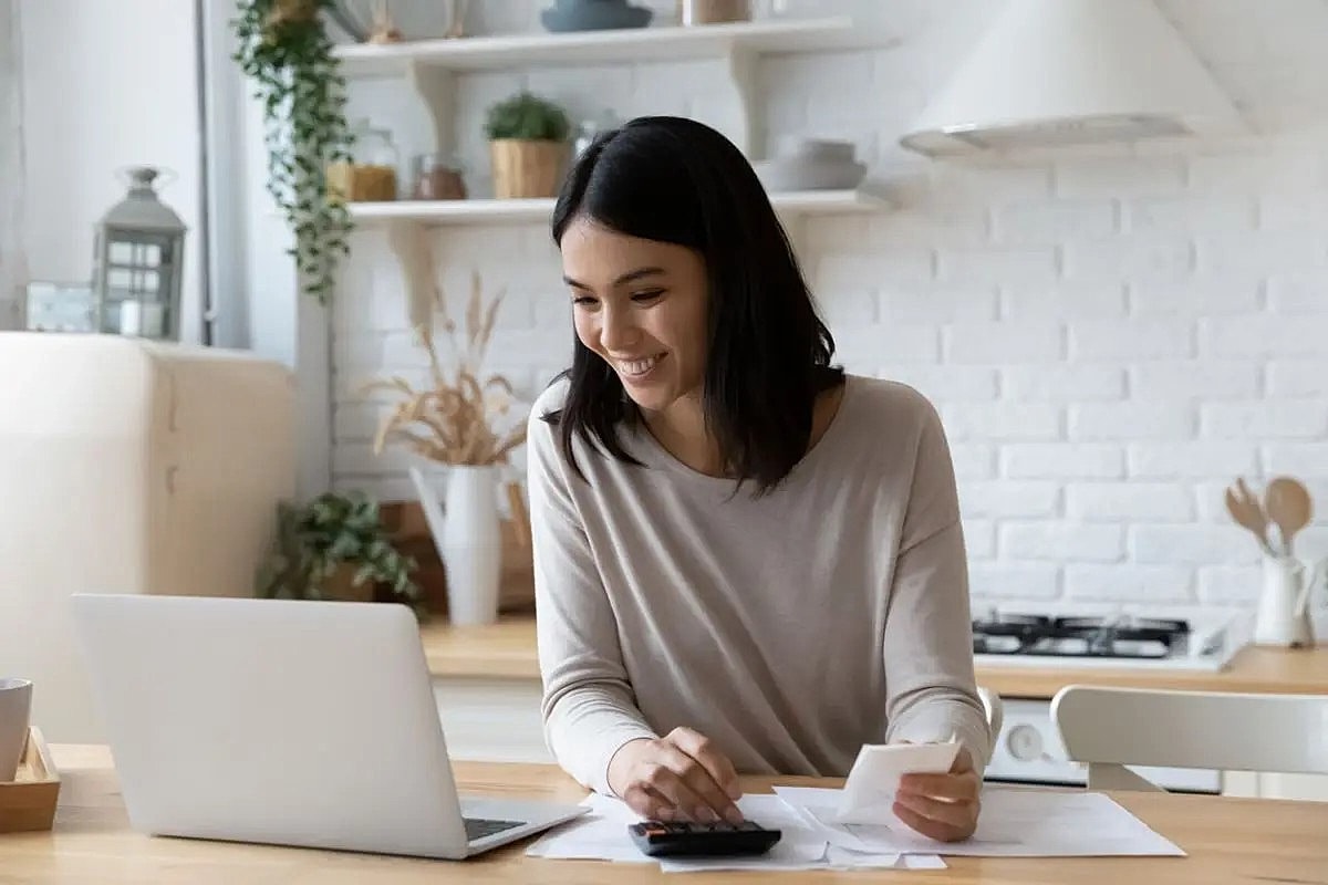 Woman calculating expenses at home office.