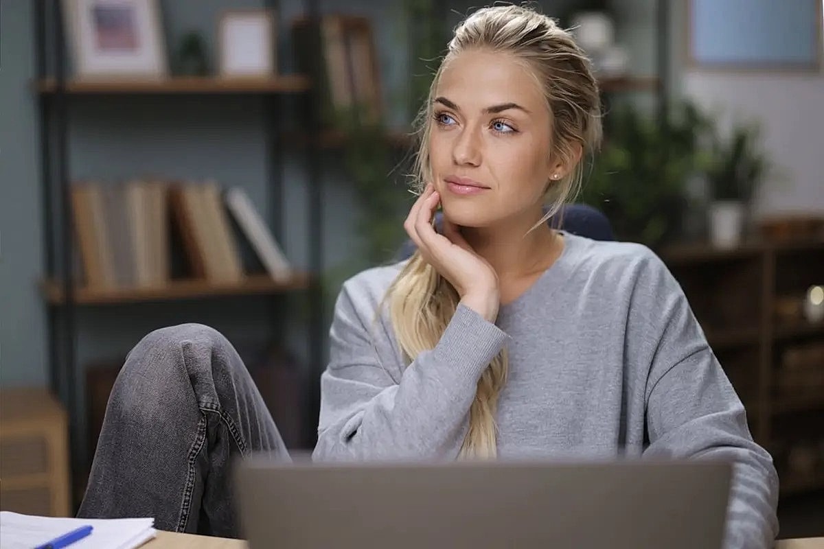 Thoughtful woman sitting at a workspace.