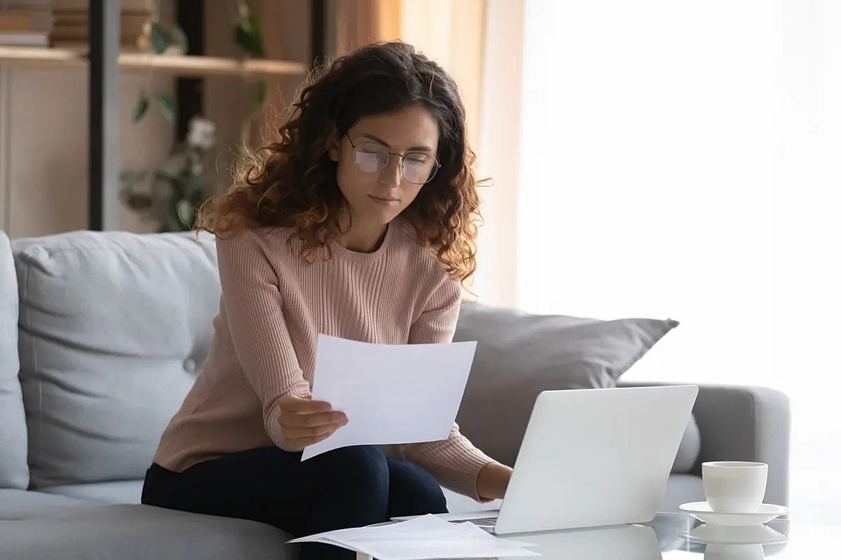 Woman reviewing documents at home office.